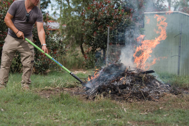 Man tending burning pile of yard waste